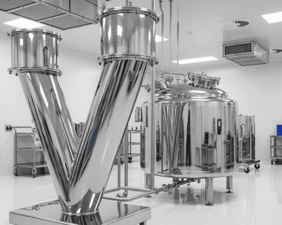 Custom stainless steel V-blender and GMP-compliant pharmaceutical mixing tank installed in a cleanroom manufacturing facility